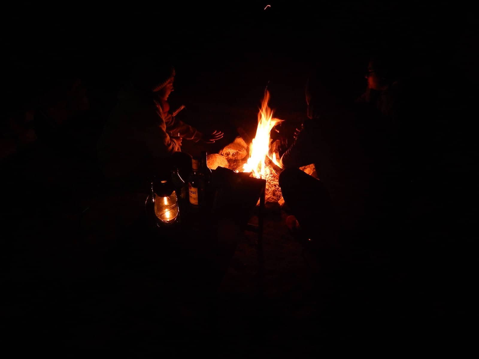 Night campfire with glowing embers and lanterns